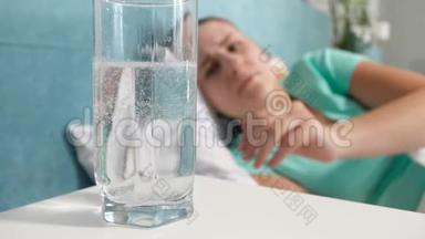 4k小女子头部疼痛躺在床上，玻璃杯中喝阿司匹林的特写视频